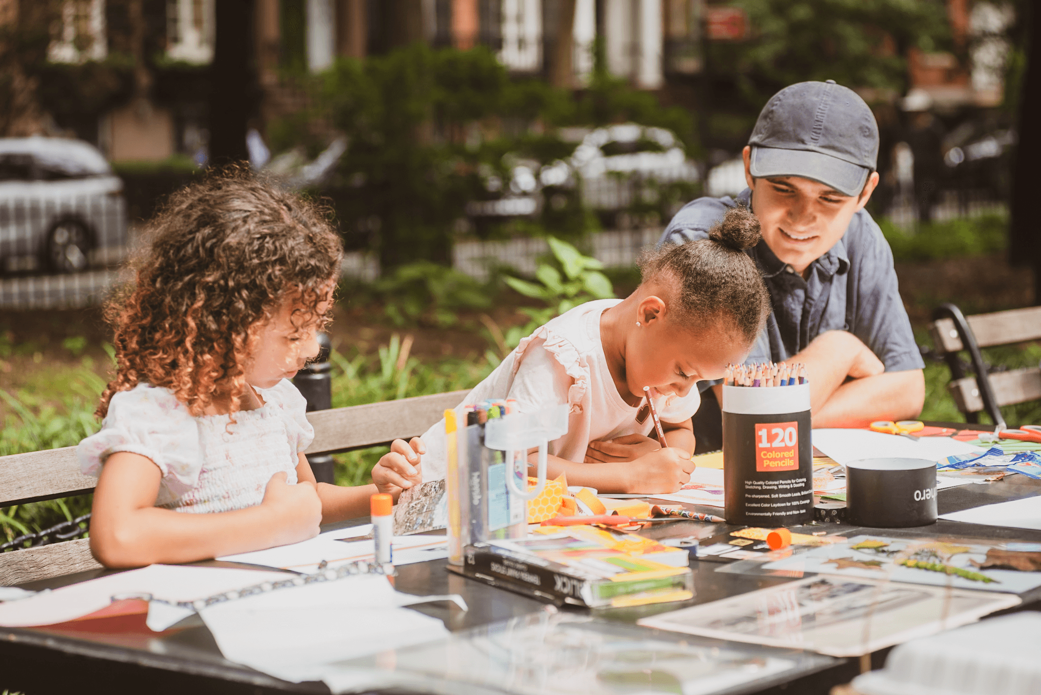 Two children work with a Conservancy team member at a Park Open Studio art workshop.