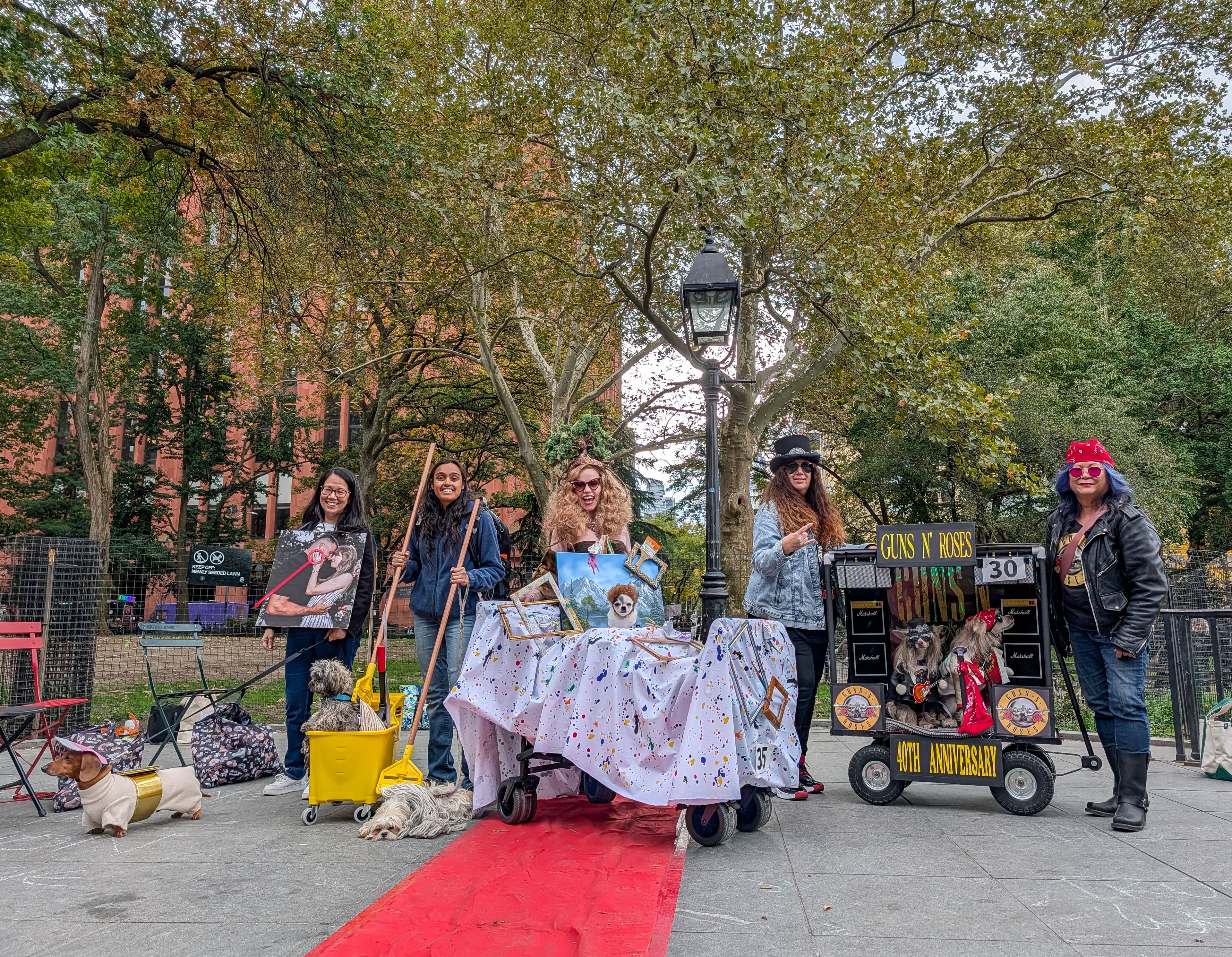 Dogs and their people dressed up in costumes in Washington Square Park.