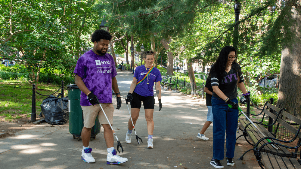 People hold trash grabbers in Washington Square Park.